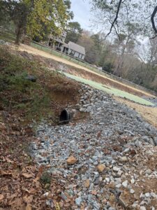 A yard with a culvert pipe installed for drainage.