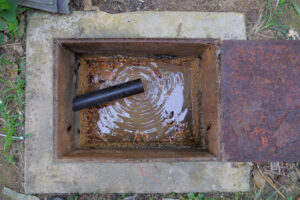 A septic tank has a hose in it and is being cleaned out.