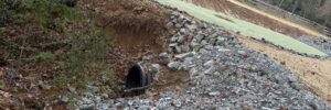 A yard with a culvert pipe installed for drainage.