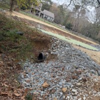 A yard with a culvert pipe installed for drainage.